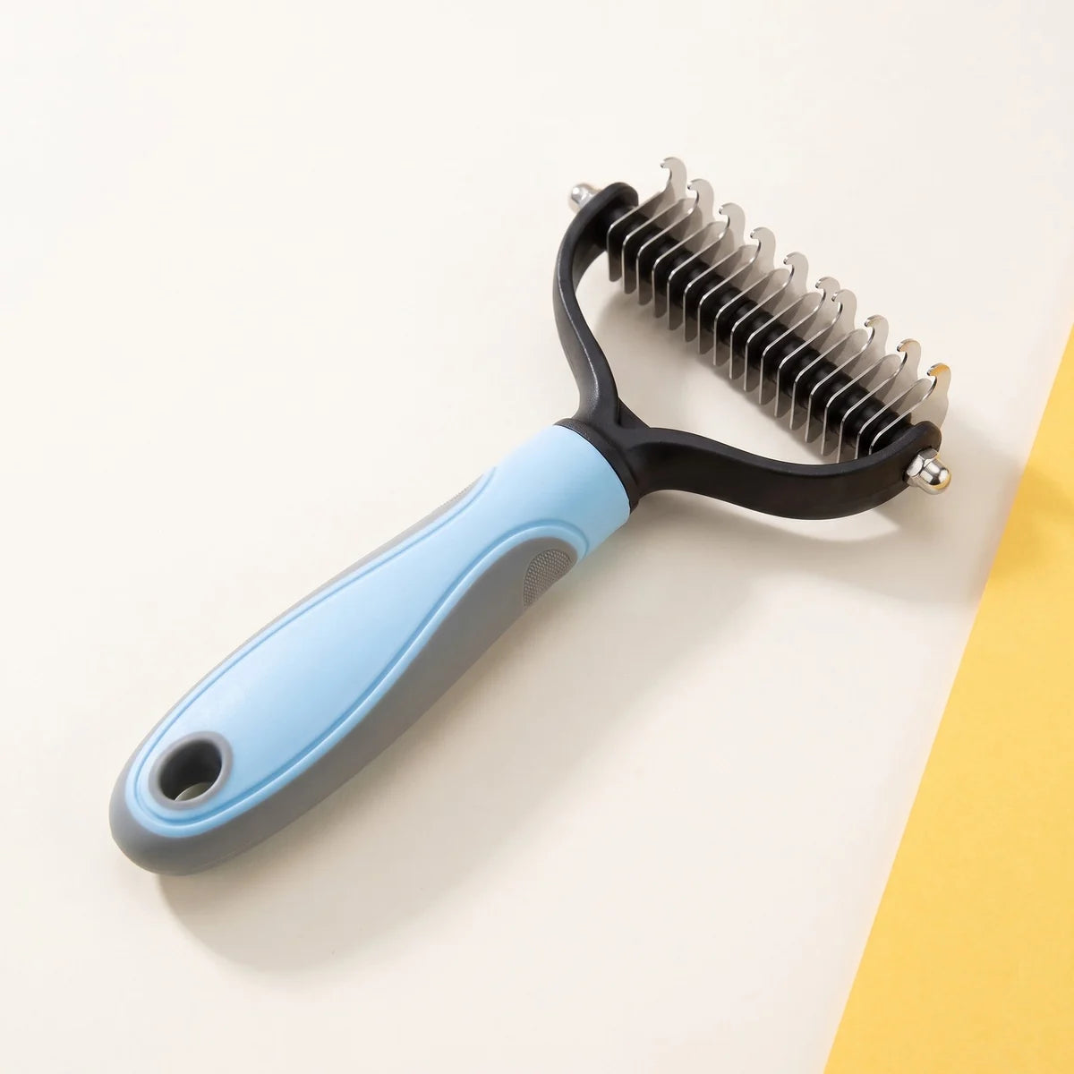 The undercoat rake, blue and grey handle, stainless blades